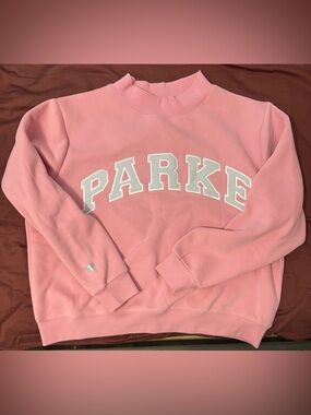 Parke Valentine’s Varsity Mockneck in Blush with lavender letters.
